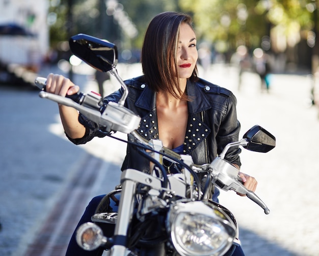 Rowerzysta dziewczyna w skórzanej kurtce na motocyklu