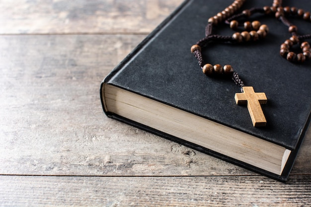 Różaniec katolicki krzyż na Biblii na drewnianym stole