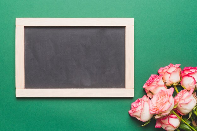 Róże blisko chalkboard na zieleni