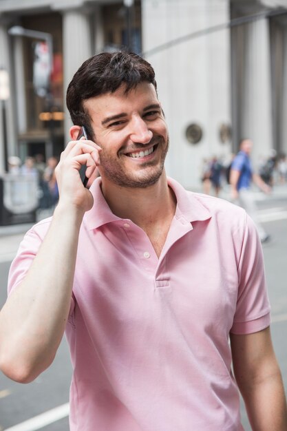 Roześmiany mężczyzna seaking na telefonie i patrzejący kamerę