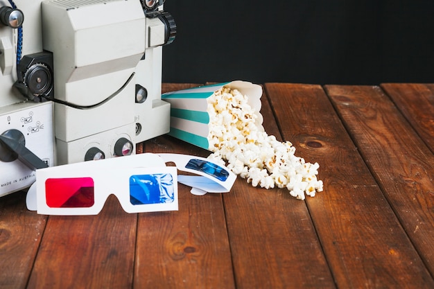 Bezpłatne zdjęcie rozlany popcorn i okulary 3d w pobliżu projektora