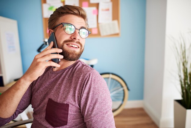 Rozmawia przez telefon i odwraca się w stronę okna