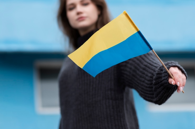 Bezpłatny plik Zdjęcie rozmyta kobieta trzymająca ukraińską flagę