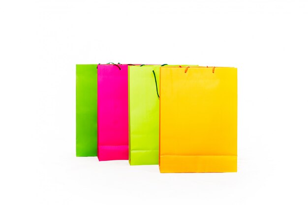 Różne kolorowe torby na zakupy, w tym żółty, pomarańczowy, różowy i zielony na białym tle