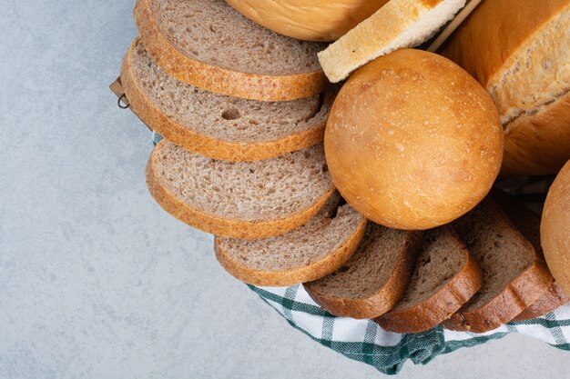 Różne pieczywo w koszu na tle marmuru. Wysokiej jakości zdjęcie