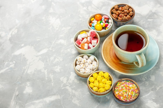 Różne Słodkie Cukierki Z Piankami I Filiżanką Herbaty Na Białym Biurku
