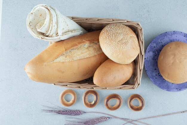 Różnorodność chleba w koszu i krakersów na kamiennej powierzchni