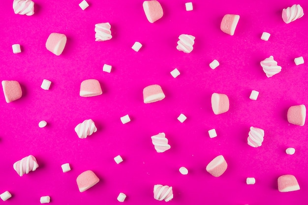 Różny kształt marshmallows na różowym tle