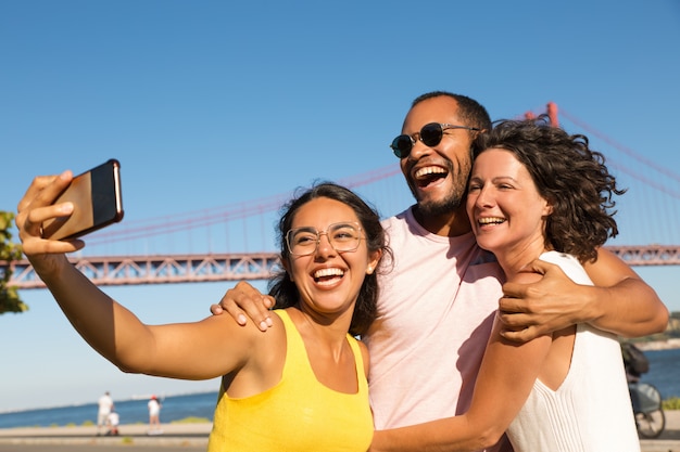 Rozochoceni przyjaciele bierze selfie z smartphone