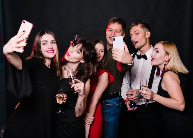 Rozochoceni przyjaciele robi selfie z iskrzastym winem