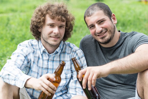Rozochoceni przyjaciele z piwem na gazonie