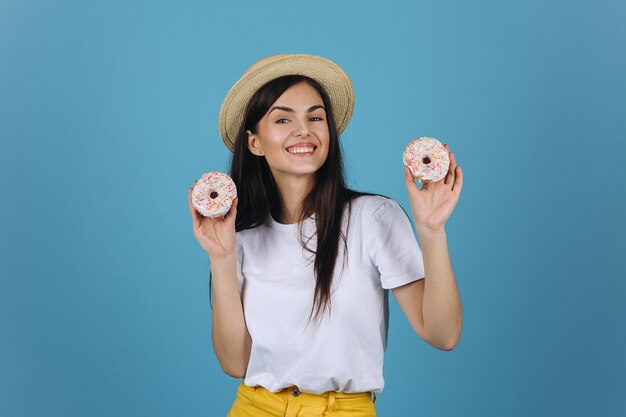 Rozochocona brunetka zabawę pozuje z wyśmienicie donuts w studiu