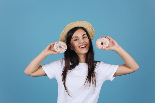 Rozochocona brunetka zabawę pozuje z wyśmienicie donuts w studiu