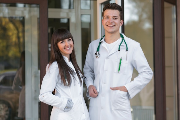 Bezpłatne zdjęcie rozochocona mężczyzna i kobiety lekarki przy kliniką