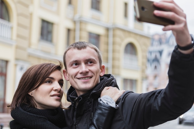 Bezpłatne zdjęcie rozochocona para strzela selfie w miasteczku