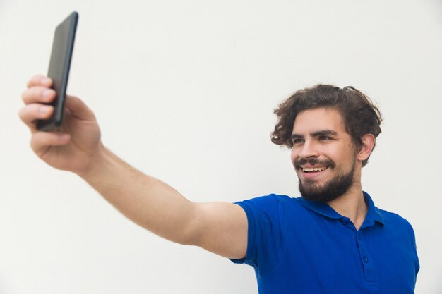 Rozochocony facet bierze selfie na telefonie komórkowym