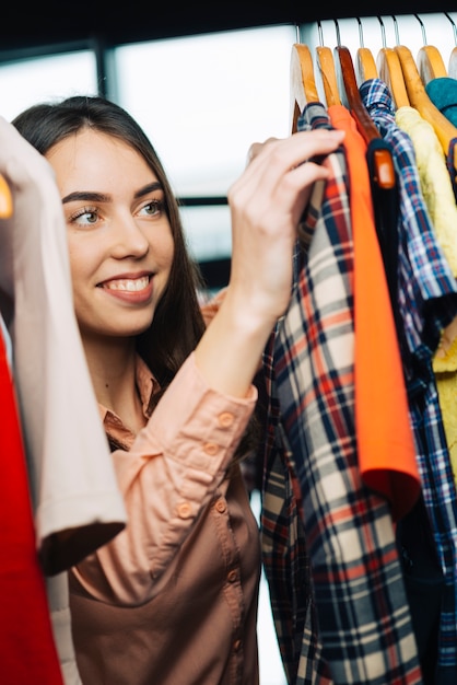 Rozochocony kobiety wybierać odziewa w sklepie