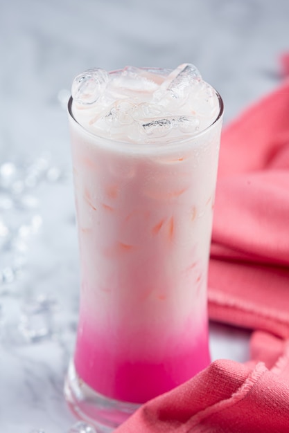 Bezpłatne zdjęcie różowe gorące mleko w szkle z pięknym dekoracyjnym wzorem marmuru.