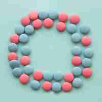 Bezpłatne zdjęcie różowe i niebieskie cukierki ułożone w okrągły kształt na kolorowym tle