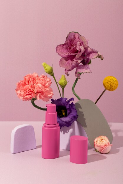 Różowe pojemniki kosmetyczne i kwiaty