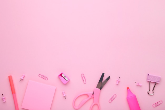 Różowe szkolne akcesoria na różowym tle. powrót do koncepcji szkoły, minimalizm