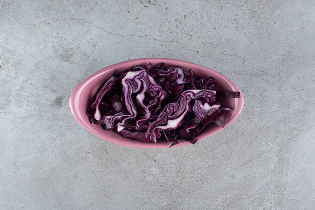 Różowy talerz z pokrojoną w plasterki fioletową kapustą. Zdjęcie wysokiej jakości