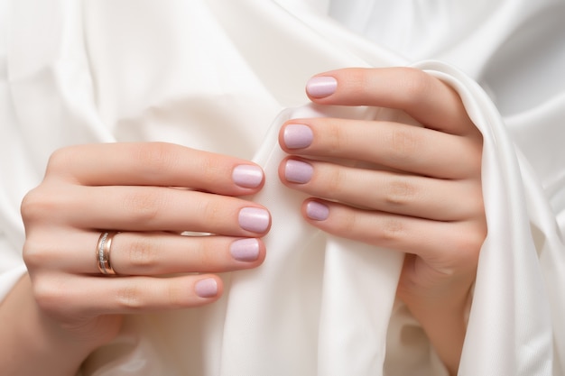 Różowy wzór paznokci. Kobiece dłonie manicure z brokatem.