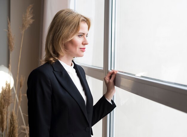 Rozważna biznesowa kobieta patrzeje okno