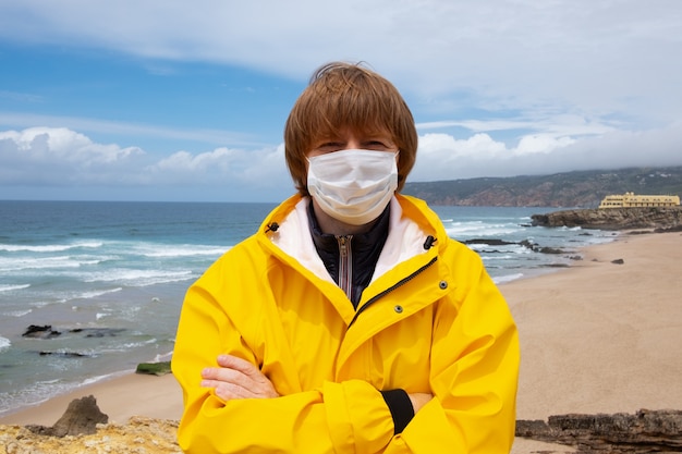 Bezpłatne zdjęcie rudowłosy facet ubrany w maskę i żółty płaszcz przeciwdeszczowy