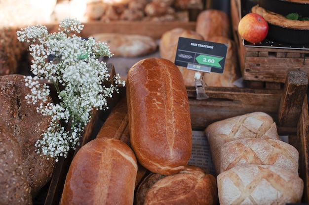 Bezpłatne zdjęcie rustykalne bochenki piekły chleb z kwiatami znacznika i łyszczca