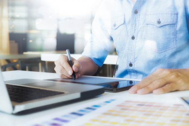 Rysunek artysta na graficznym tablecie z próbkami kolorów w biurze. Rysunek architektoniczny z narzędziami roboczymi i akcesoriami.