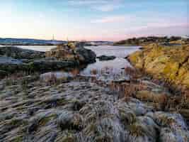 Bezpłatne zdjęcie rzeka otoczona skałami pod słońcem w ostre halsen w norwegii