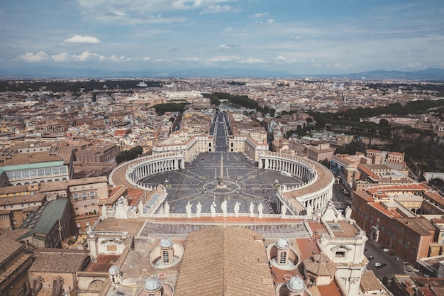 Rzym, włochy - 22 czerwca 2018: panoramiczny widok na plac świętego piotra i rzymu z papieskiej bazyliki świętego piotra (bazylika świętego piotra). letni dzień i ludzie chodzą po placu