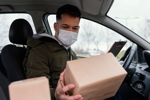 Samiec dostawy z maską i paczkami