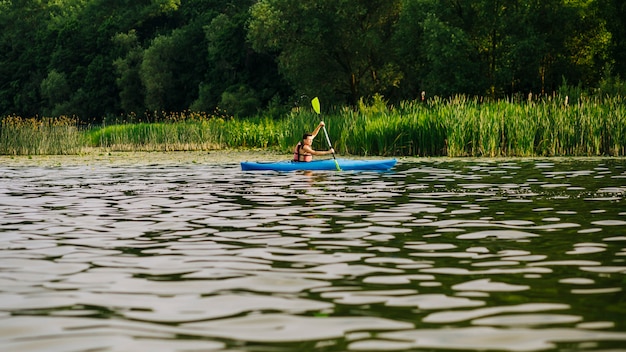 Samiec kayaking z paddle na wodnej czochry powierzchni