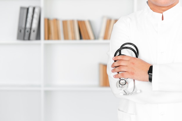 Bezpłatne zdjęcie samiec lekarki ręka trzyma stetoskop