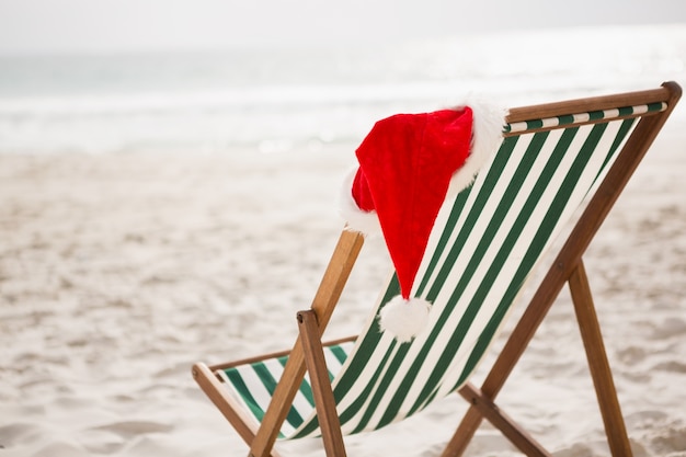 Santa hat przechowywane na pustej plaży krzesło