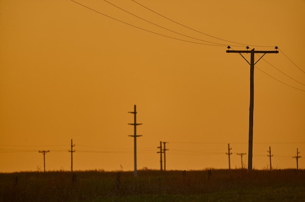 Sceneria zachodu słońca w napowietrznej linii energetycznej