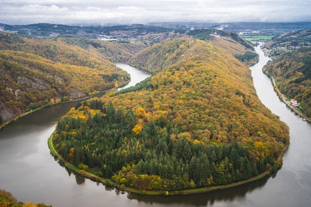 Ścieżka w koronach drzew Saarschleife pod zachmurzonym niebem jesienią w Niemczech