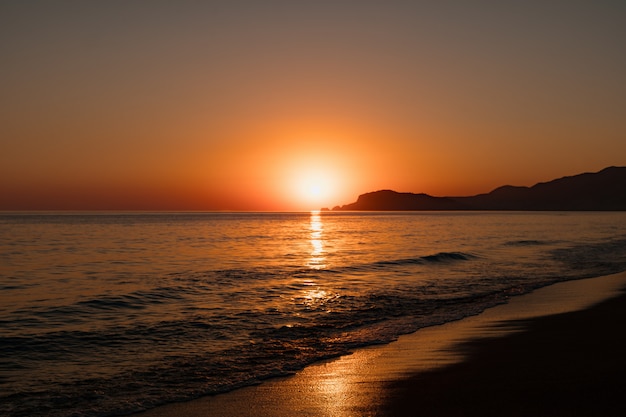 Seascape z czystym niebem i falami na zachodzie słońca