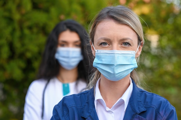 Selektywne ujęcie ostrości lekarzy noszących maski na twarz na zewnątrz