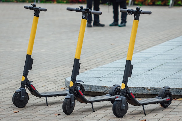 Bezpłatne zdjęcie selektywne ujęcie trzech skuterów elektrycznych na chodniku