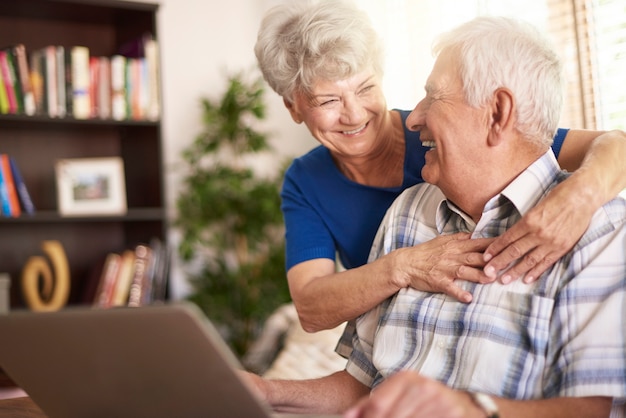 Senior małżeństwo za pomocą laptopa w salonie