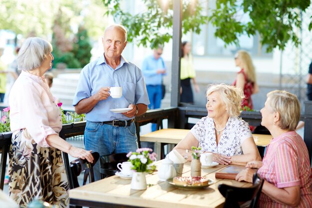 Seniorzy spędzający czas w kawiarni na świeżym powietrzu