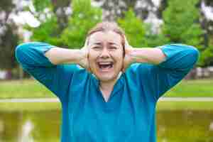 Bezpłatne zdjęcie sfrustrowana nieszczęśliwa kobieta cierpi z powodu głośnych dźwięków