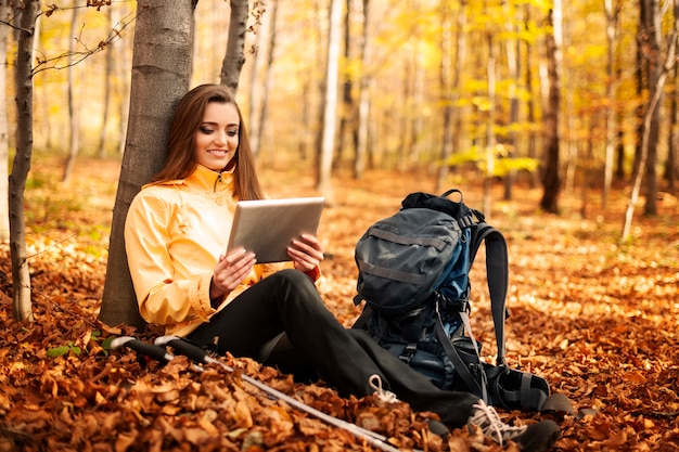 Siedzący turysta kobieta za pomocą cyfrowego tabletu