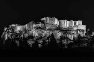 Bezpłatne zdjęcie skala szarości świątyni zeusa olimpijskiego pod światłami w otoczeniu drzew w nocy