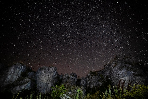 Bezpłatne zdjęcie skaliste góry i gwiaździste nocne niebo