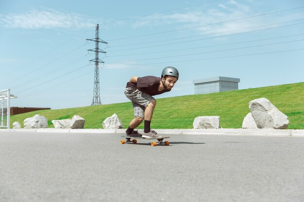 Skateboarder robi figla na miejskiej ulicy w słoneczny dzień.