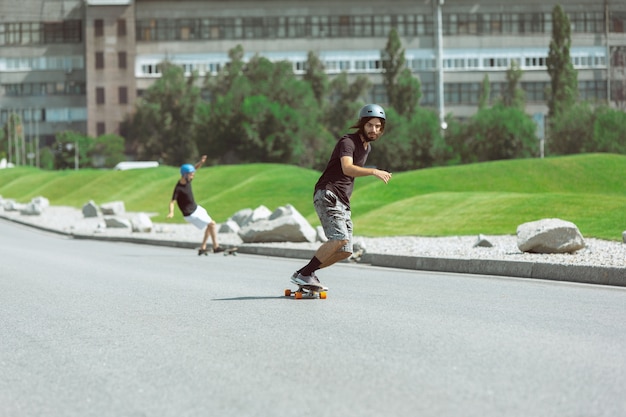 Bezpłatne zdjęcie skateboardziści robią sztuczkę na miejskiej ulicy w słoneczny dzień
